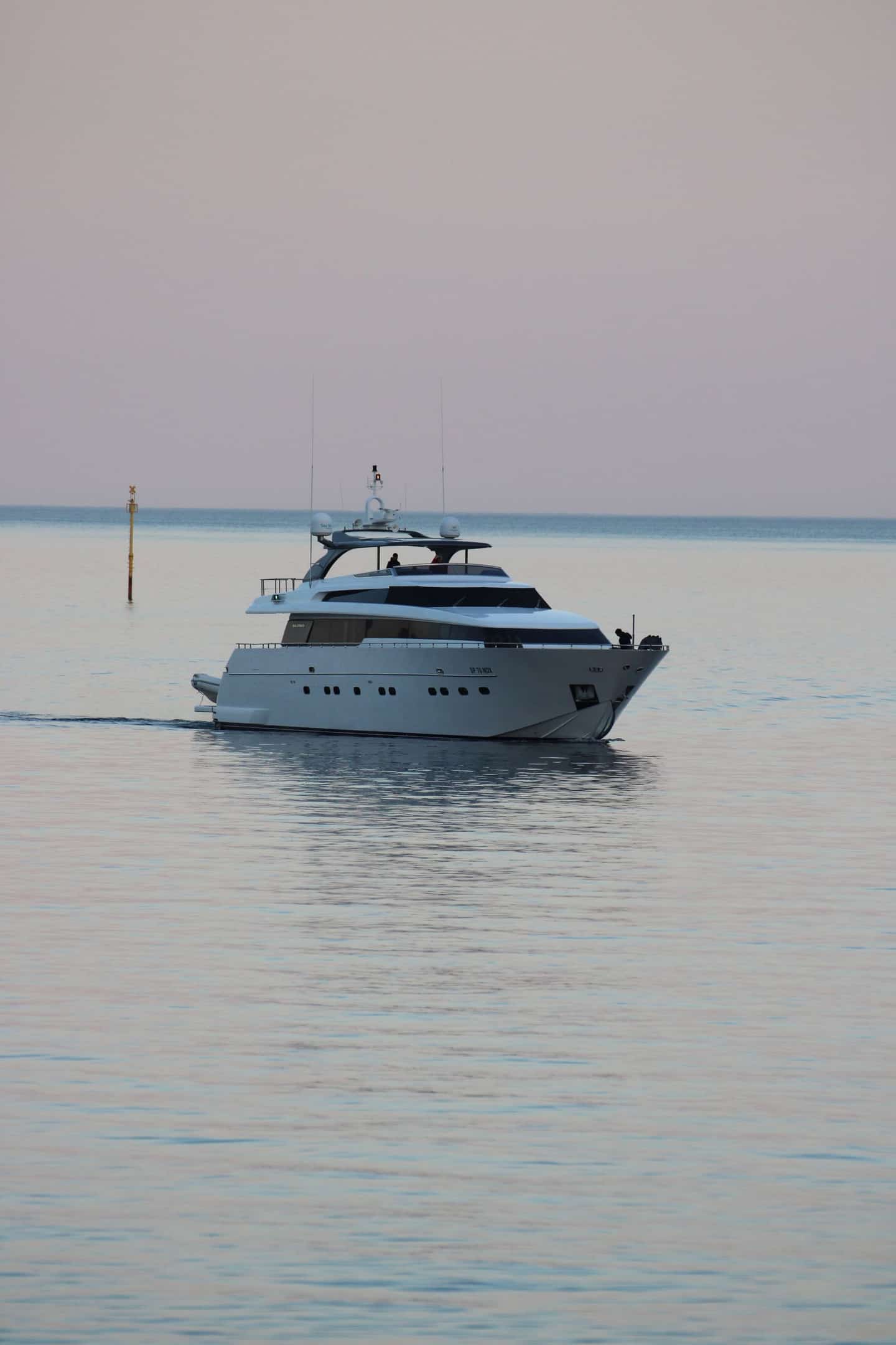 Motor yacht cruising off the Italian coast at dusk